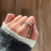 Natural jadeite ring with round light jade stone on red cord band in hand