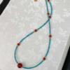 Turquoise beaded necklace with red agate round beads, gold hook clasp.