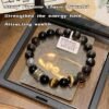 Dark bead protection bracelet with silver-toned bead accents and gold-toned clasp