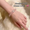Rose quartz beaded bracelet on wrist with silver-tone sparkling spacers