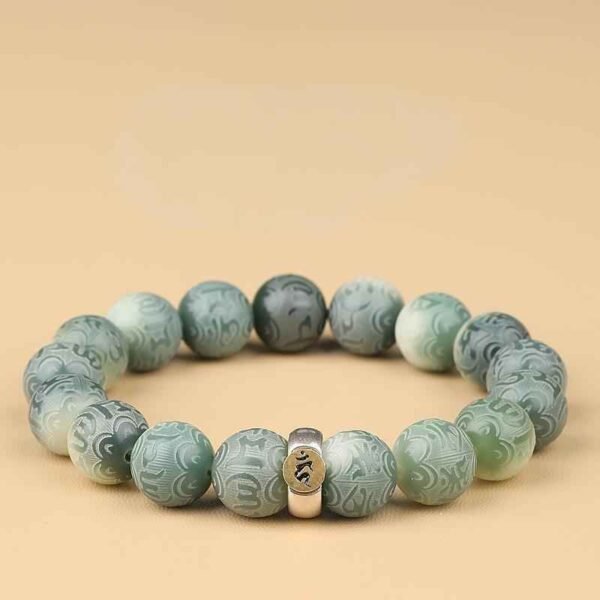 Green bodhi bead bracelet with carved jade-like beads and central metal charm centerpiece