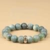 Green bodhi beaded bracelet, circular layout with carved beads and central metal charm