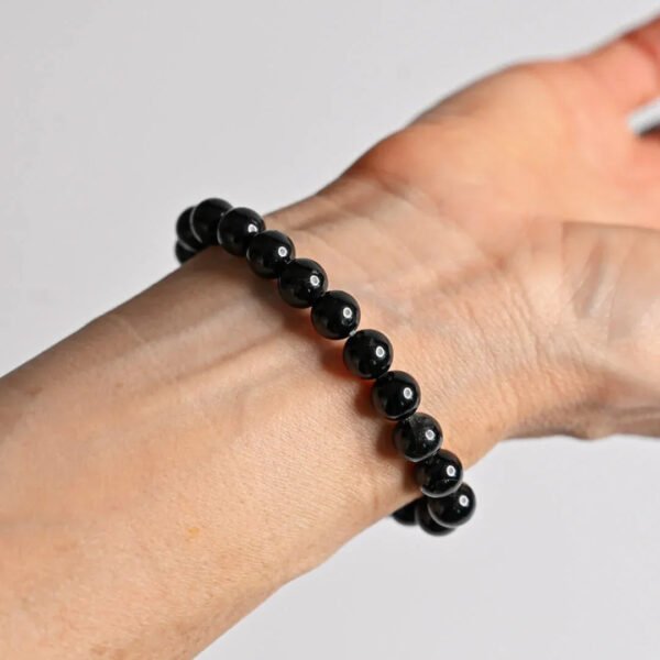 Black gemstone beaded bracelet on wrist, elastic string style