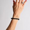 Beaded bracelet of round black stones worn on wrist
