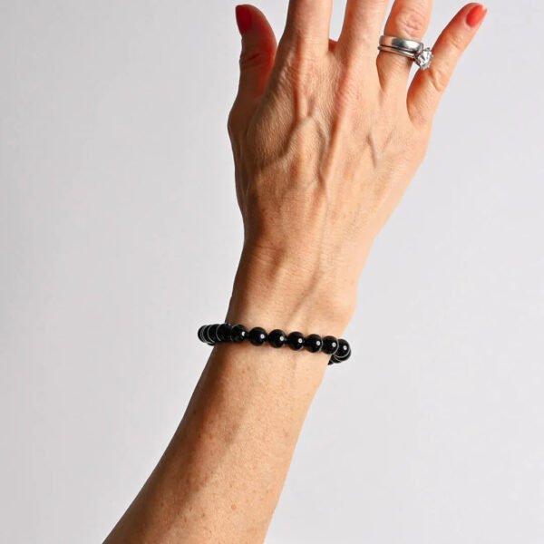 Beaded bracelet of round black stones worn on wrist