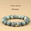 Green bodhi beaded bracelet with carved beads and central metal mantra charm, centered view