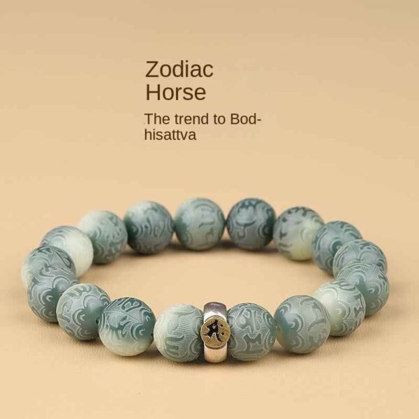 Green bodhi bracelet with round carved beads and engraved center metal talisman