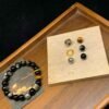 Black bead bracelet with silver charm and gold ring accent, tiger-eye center bead