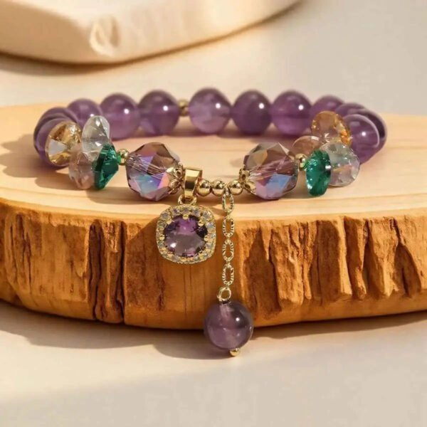 Amethyst gemstone bracelet with purple beads, gold accents, green gems, and a purple charm.